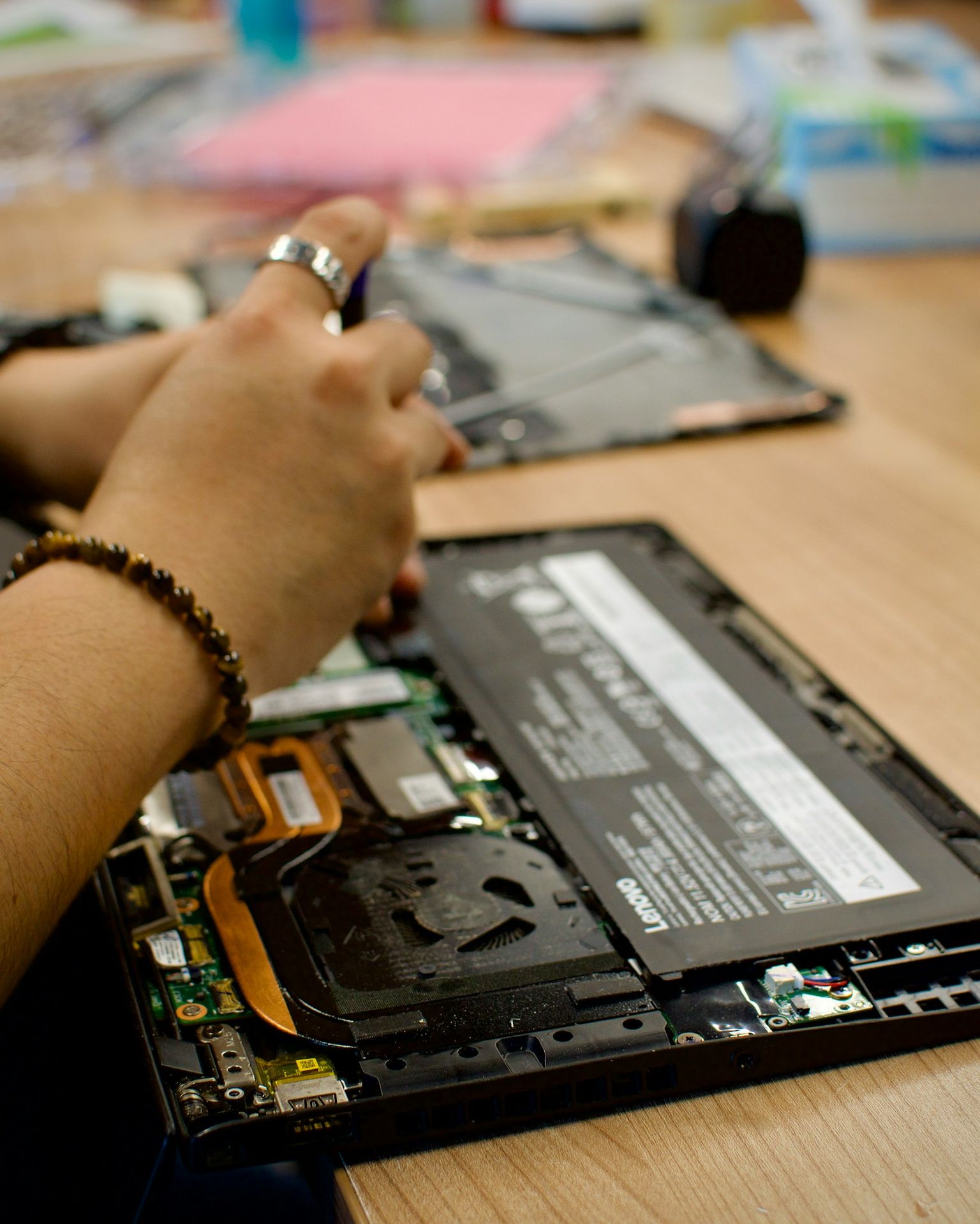 a person using a cell phone to repair a laptop